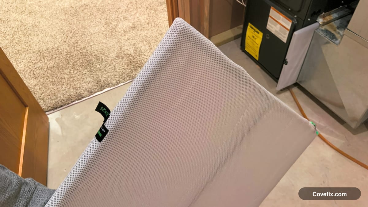 A furnace filter being held near the filter slot